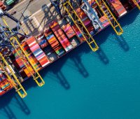 Aerial view of cargo ship and cargo container in harbor.